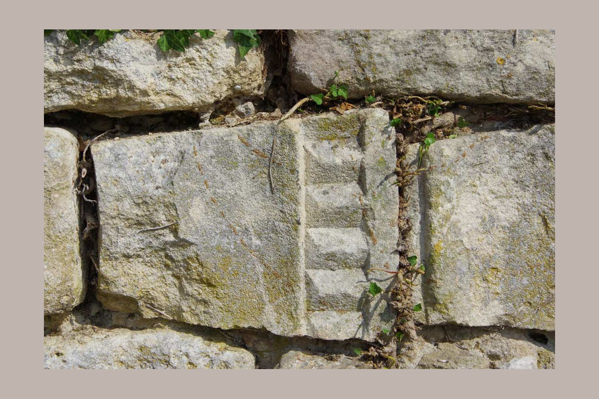pierres taillée seule venant du prieuré saint maurice, sur le mur du cimetière de chantemerle les grignan