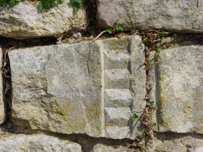 pierres taillée seule venant du prieuré saint maurice, sur le mur du cimetière de chantemerle les grignan